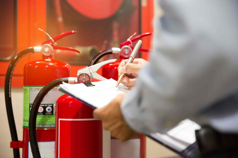 Profissional inspeciona extintores para verificar conformidade com o licenciamento AVCB ou CLCB.